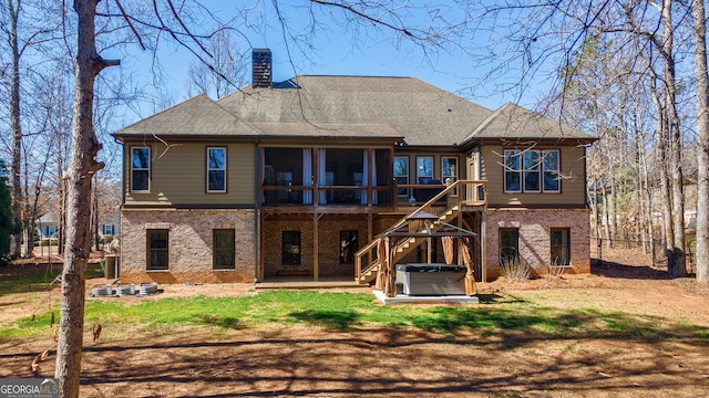 rear view of property with a patio, a sunroom, brick siding, a chimney, and a hot tub