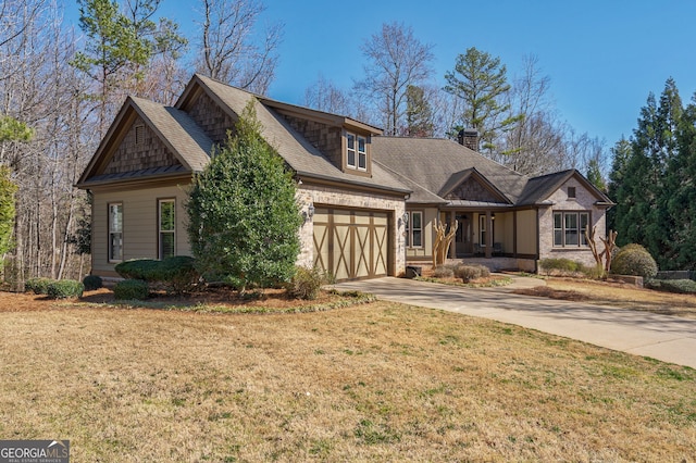 craftsman inspired home with concrete driveway, a front yard, roof with shingles, a chimney, and an attached garage