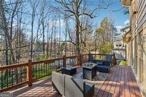 wooden terrace with an outdoor living space with a fire pit