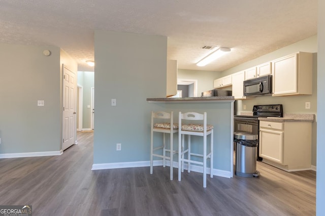 kitchen featuring visible vents, black appliances, white cabinets, baseboards, and dark wood-style flooring