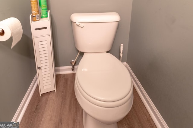 bathroom featuring toilet, baseboards, and wood finished floors