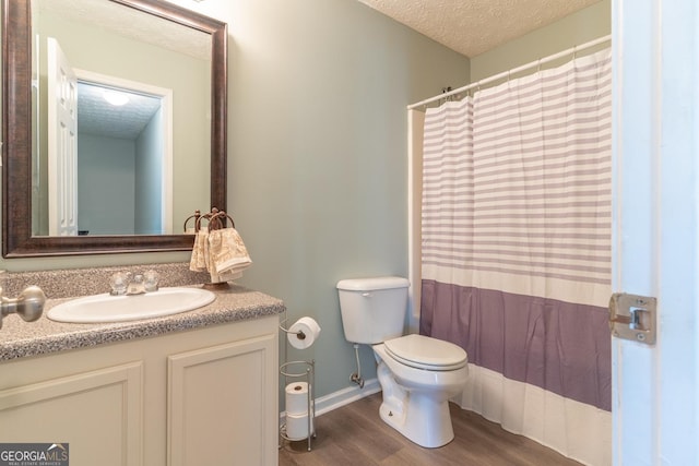 full bath with vanity, wood finished floors, a textured ceiling, curtained shower, and toilet