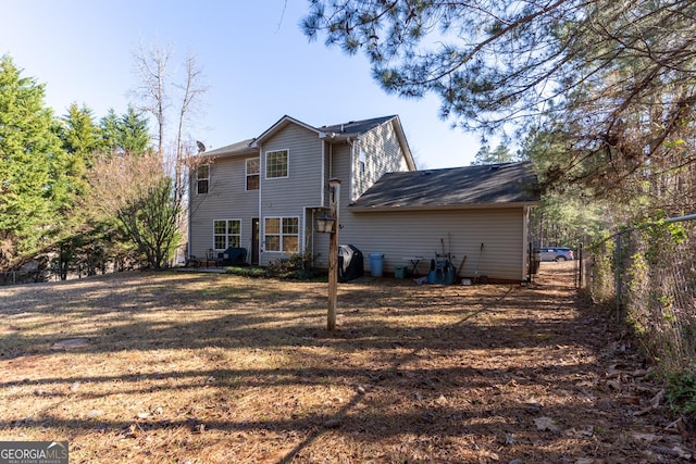 back of house with a yard and fence