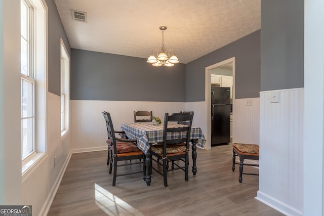 dining space featuring visible vents, wainscoting, and plenty of natural light