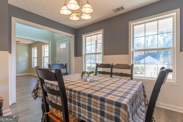 dining area featuring an inviting chandelier, a healthy amount of sunlight, and visible vents