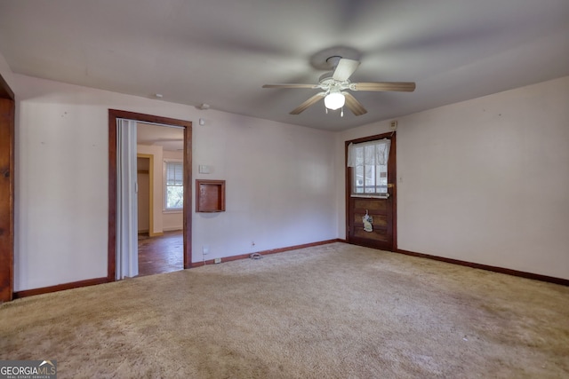 unfurnished room with carpet flooring, a ceiling fan, and plenty of natural light