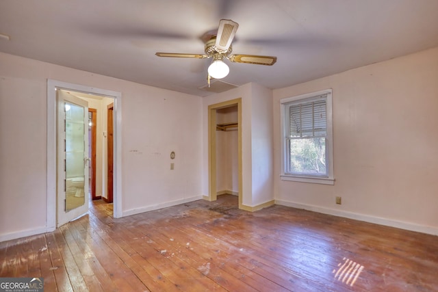 unfurnished bedroom with a closet, a ceiling fan, baseboards, and hardwood / wood-style floors