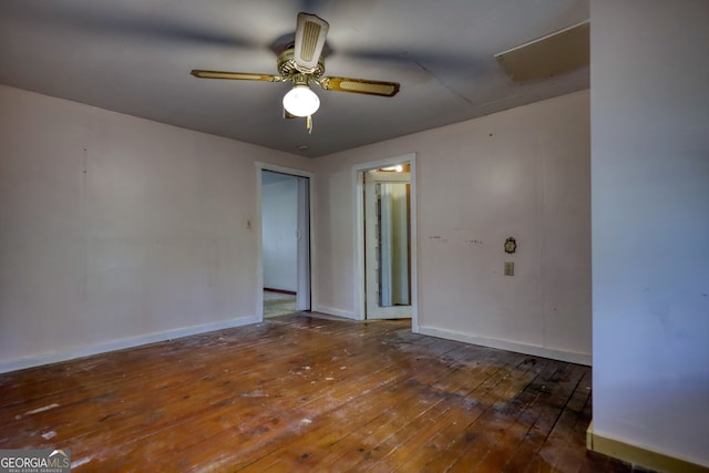 empty room featuring a ceiling fan, baseboards, and wood-type flooring