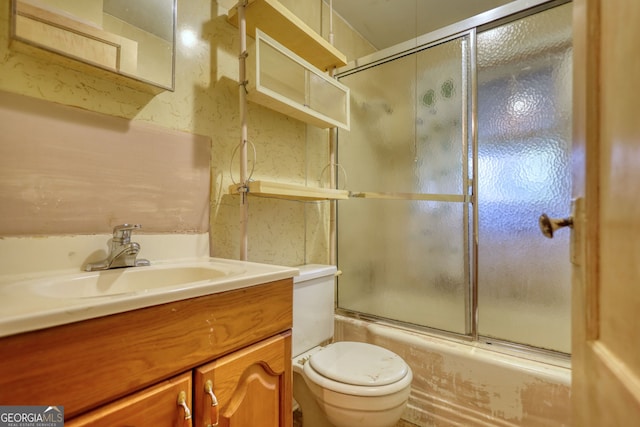 full bath featuring vanity, toilet, and shower / bath combination with glass door