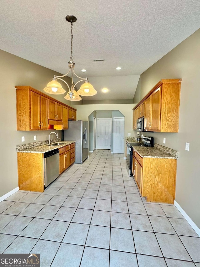 kitchen featuring visible vents, a chandelier, lofted ceiling, appliances with stainless steel finishes, and a sink