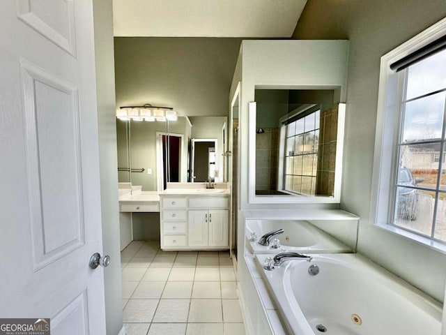 bathroom featuring tile patterned floors, a jetted tub, and vanity