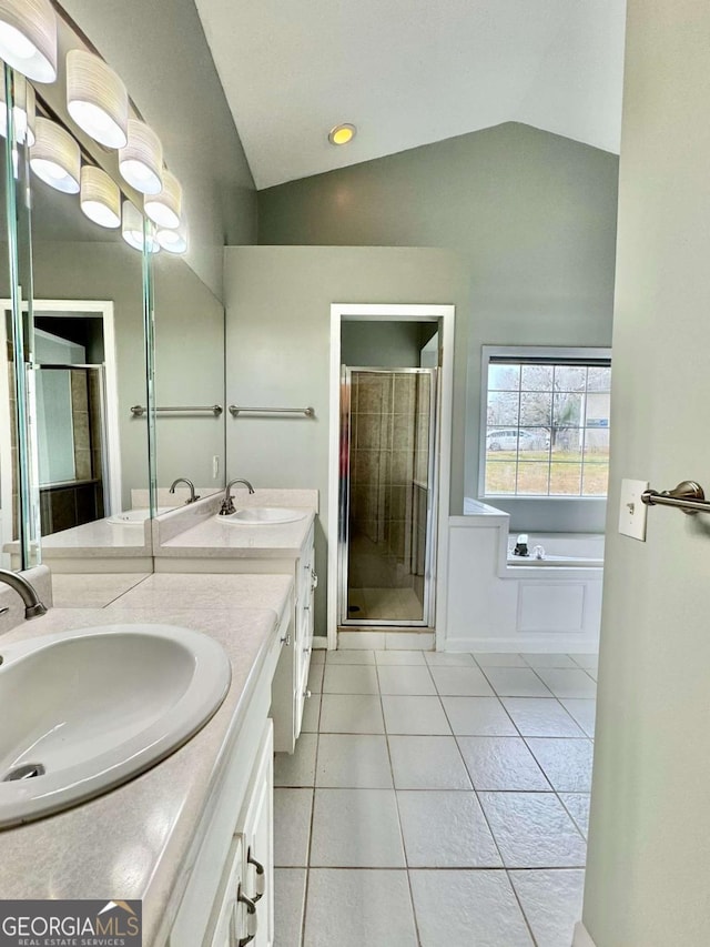 bathroom with tile patterned floors, a shower stall, lofted ceiling, and a sink