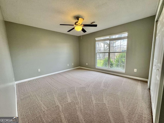 unfurnished bedroom with visible vents, ceiling fan, baseboards, carpet, and a textured ceiling