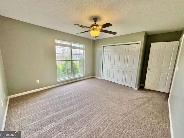 unfurnished bedroom featuring carpet flooring, baseboards, a closet, and ceiling fan