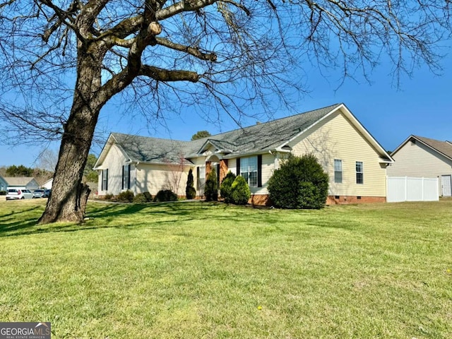 view of side of property with crawl space, a lawn, and fence