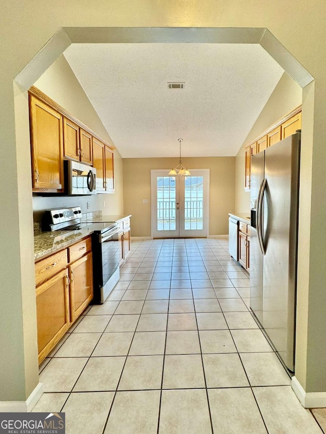 kitchen with visible vents, vaulted ceiling, appliances with stainless steel finishes, french doors, and light tile patterned flooring