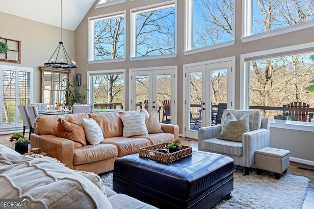 living area with plenty of natural light, french doors, visible vents, and wood finished floors