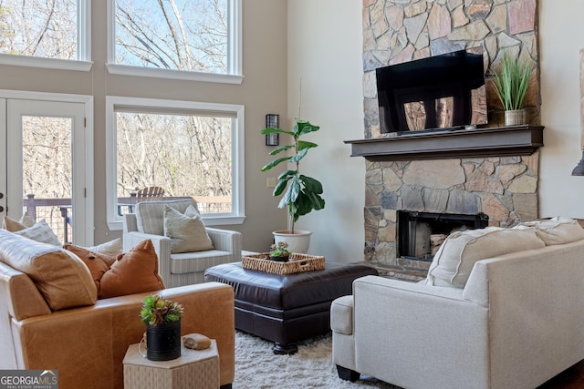 living area with a fireplace and a towering ceiling