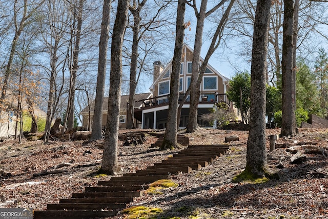 back of house featuring stairway and a chimney