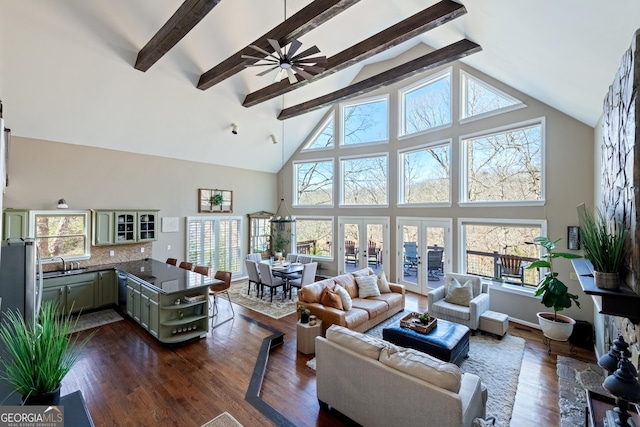 living area featuring dark wood-type flooring, high vaulted ceiling, plenty of natural light, and beam ceiling