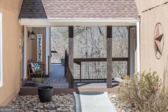 doorway to property with roof with shingles