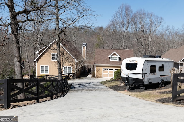 view of front of property featuring fence, a garage, and driveway