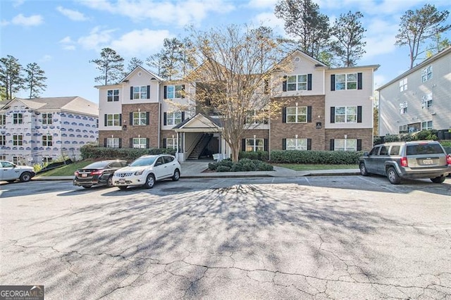 view of front of house with stairway and uncovered parking