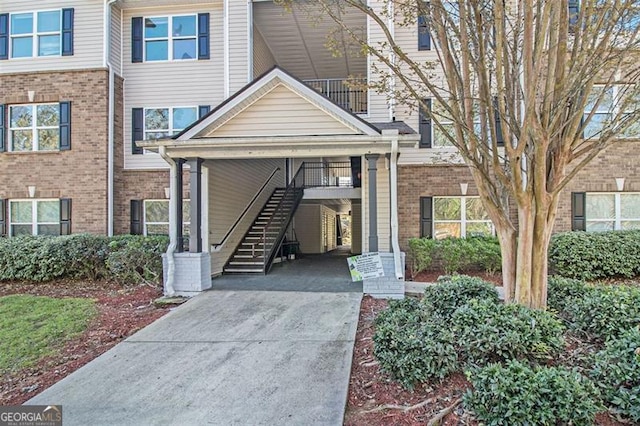 exterior space with a carport, stairway, and driveway