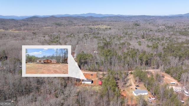 drone / aerial view with a mountain view and a forest view