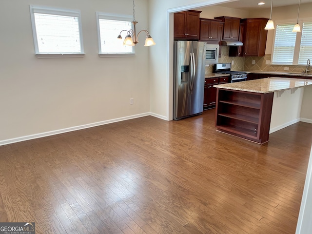 kitchen featuring dark wood-style flooring, backsplash, appliances with stainless steel finishes, and open shelves