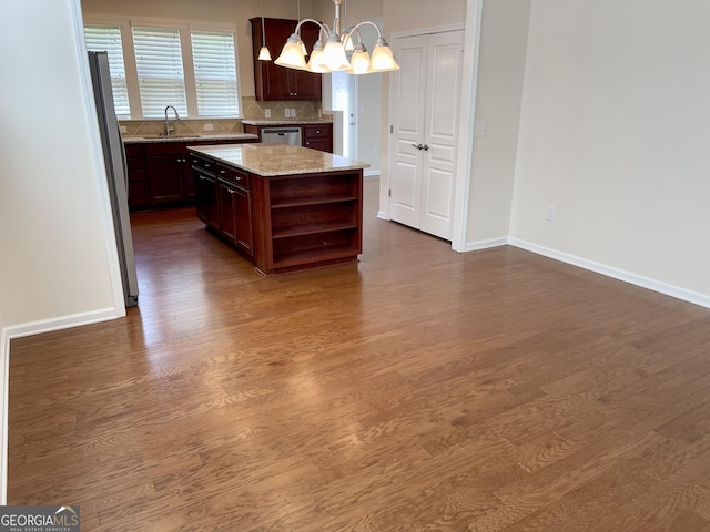 kitchen featuring a notable chandelier, a sink, dark wood-type flooring, and open shelves