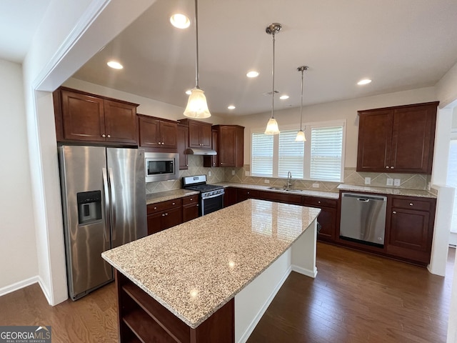 kitchen featuring a center island, dark wood-style floors, appliances with stainless steel finishes, and a sink