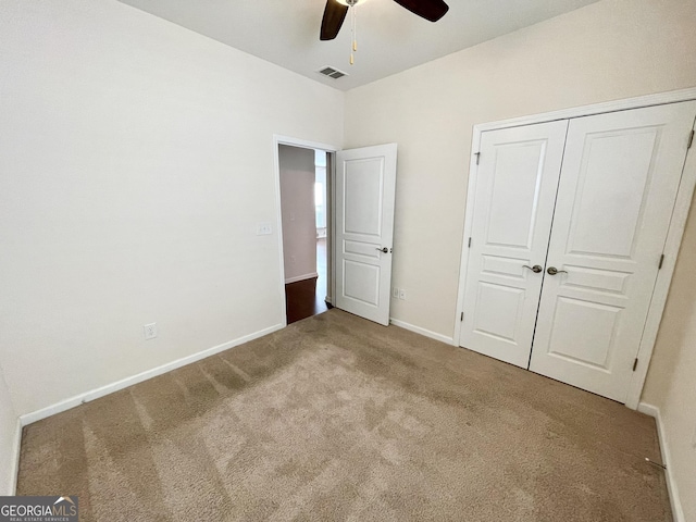 unfurnished bedroom featuring carpet flooring, baseboards, visible vents, and a closet