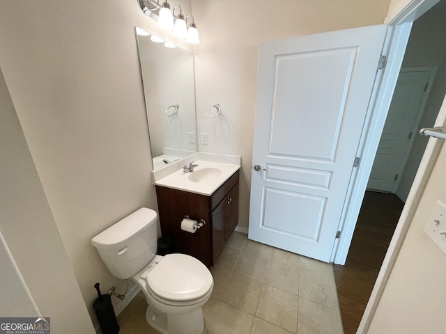 bathroom featuring tile patterned floors, baseboards, toilet, and vanity