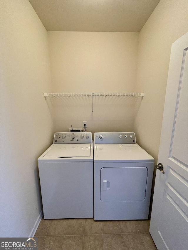 washroom featuring tile patterned flooring, laundry area, washing machine and dryer, and baseboards