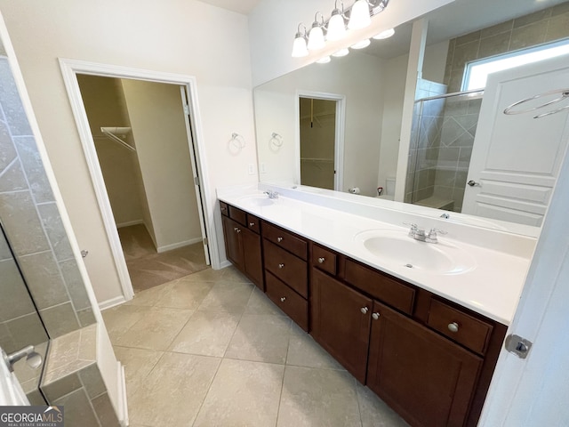 bathroom with double vanity, tile patterned flooring, a stall shower, and a sink