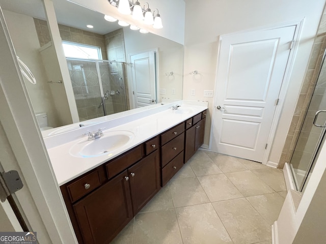 bathroom featuring tile patterned flooring, double vanity, a stall shower, and a sink