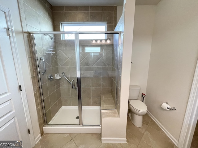 bathroom featuring baseboards, toilet, a shower stall, and tile patterned flooring