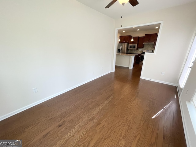 unfurnished living room with recessed lighting, baseboards, dark wood-type flooring, and a ceiling fan