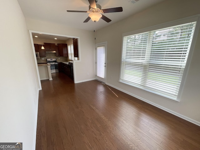 unfurnished living room featuring visible vents, baseboards, ceiling fan, and dark wood finished floors