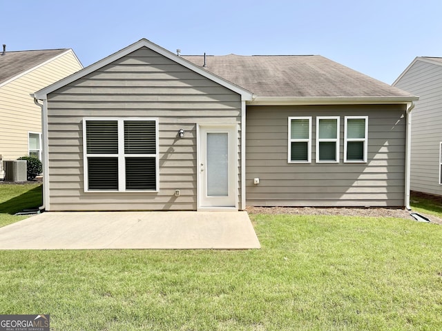 rear view of house featuring a patio, central air condition unit, a lawn, and roof with shingles