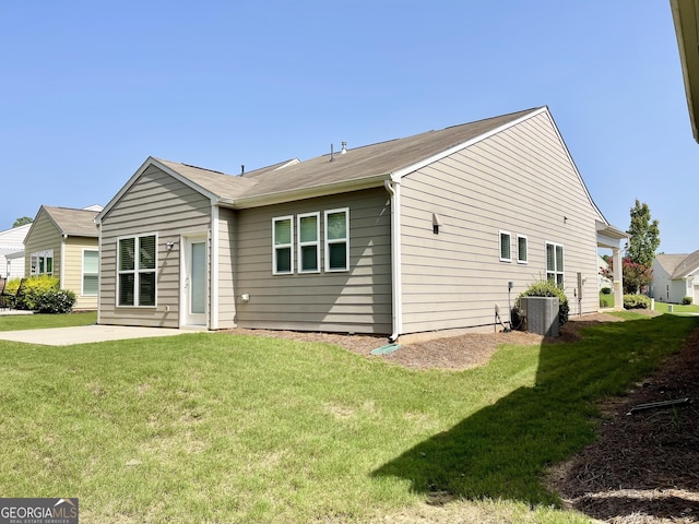 rear view of house featuring central air condition unit, a yard, and a patio area