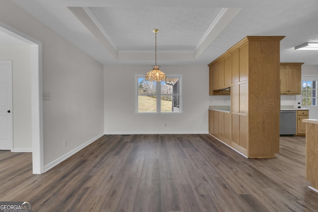 unfurnished dining area featuring dark wood finished floors, crown molding, a raised ceiling, and an inviting chandelier