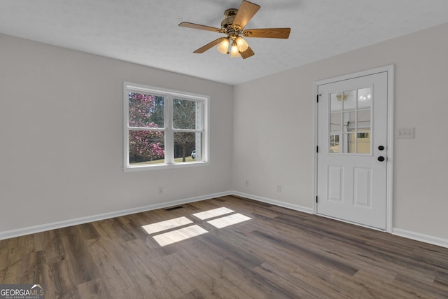 unfurnished room featuring visible vents, baseboards, and wood finished floors