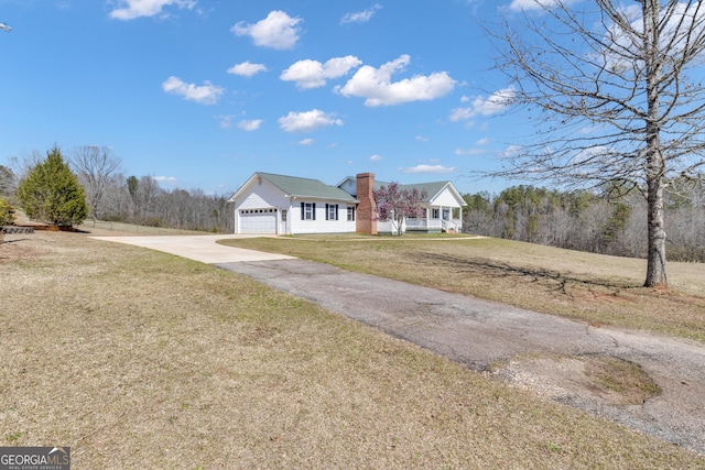 view of front facade with a front yard, an attached garage, and driveway