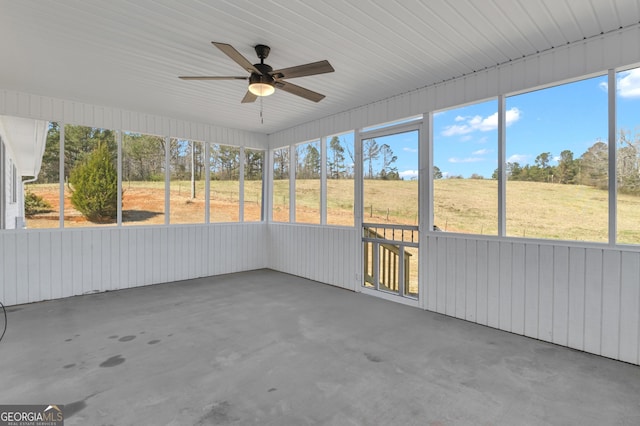 unfurnished sunroom featuring a ceiling fan