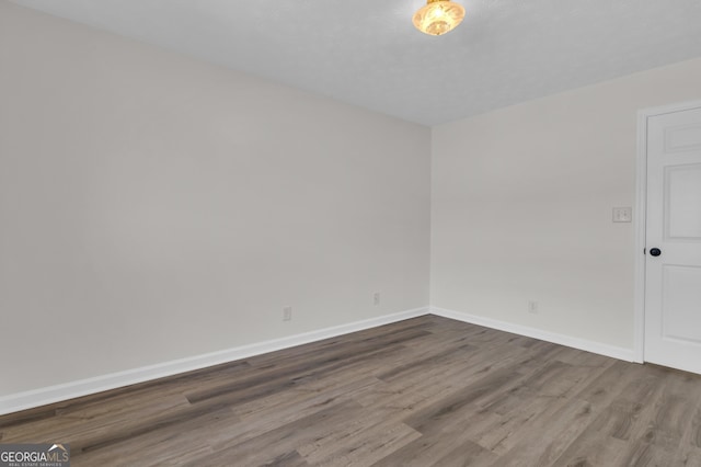 unfurnished room featuring wood finished floors and baseboards