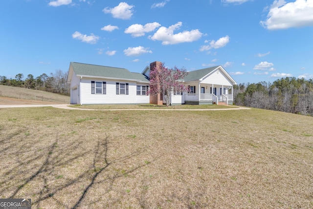 view of front of house with a garage, driveway, a porch, and a front yard