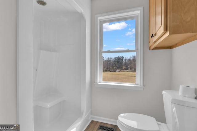 full bathroom featuring visible vents, baseboards, toilet, and walk in shower