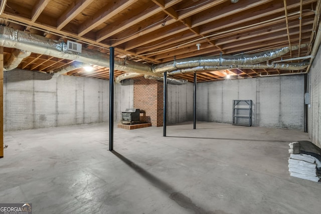 unfinished basement with visible vents and brick wall